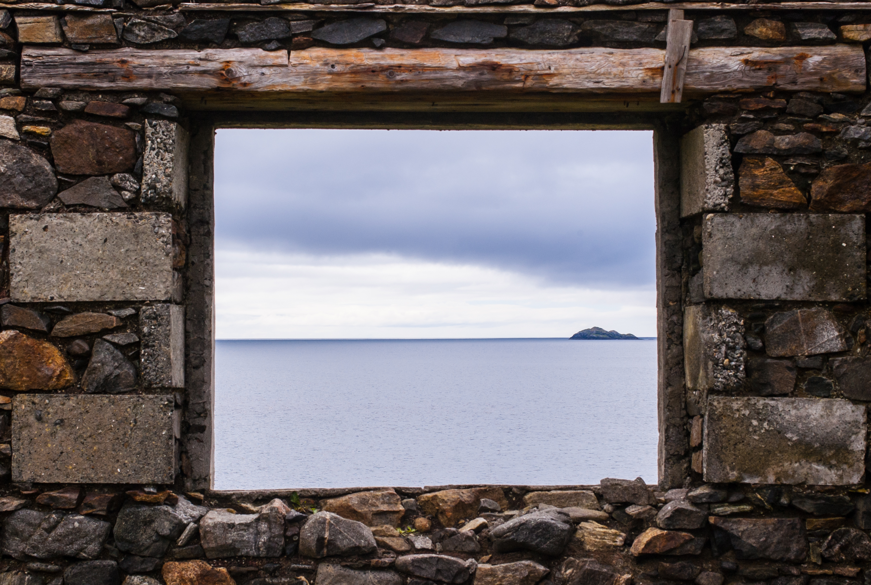 Sea view from a stone window of an old ruin near the ocean in the Isle of Harris, Scotland